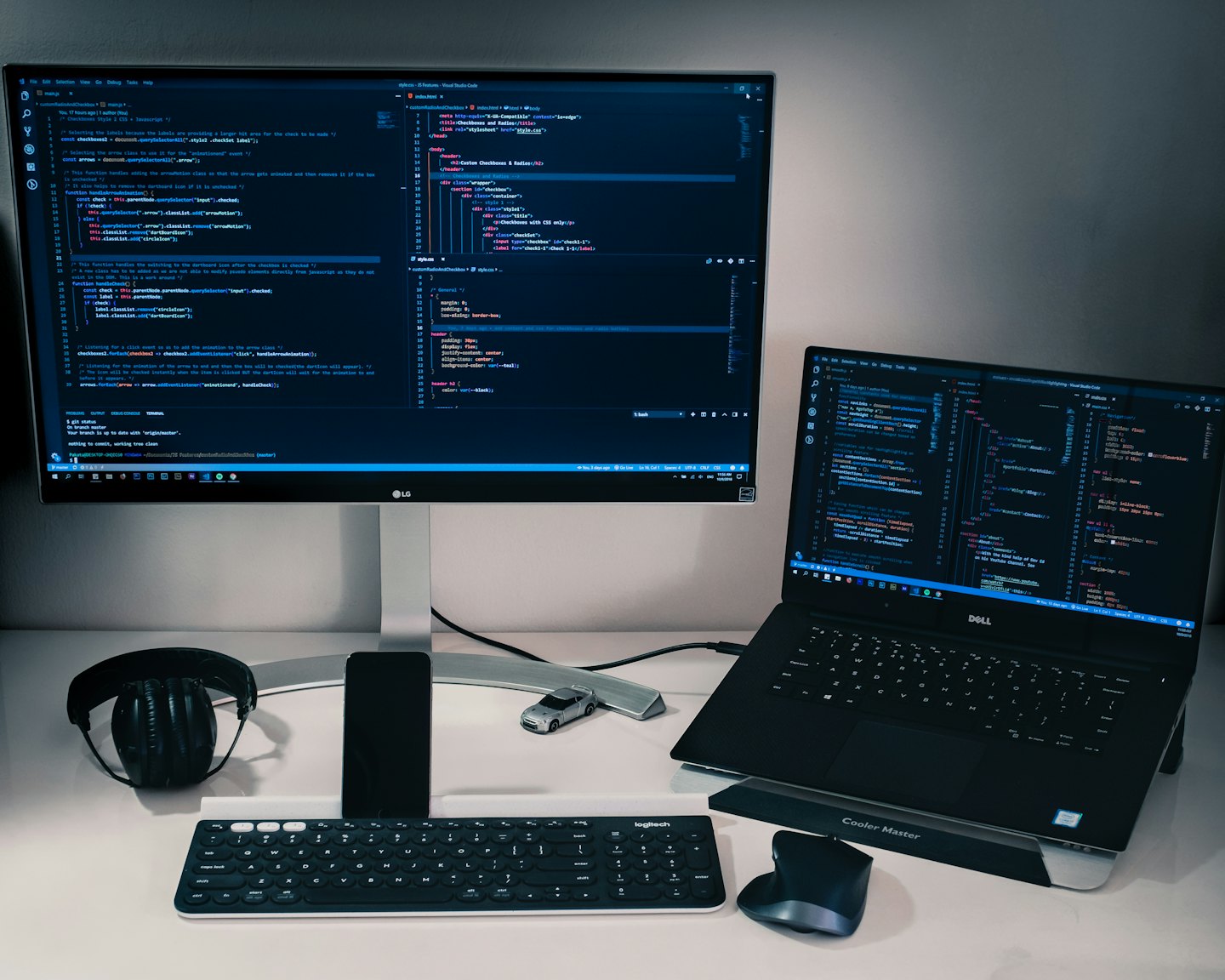 Programmer's desk with code on monitors and tech accessories.